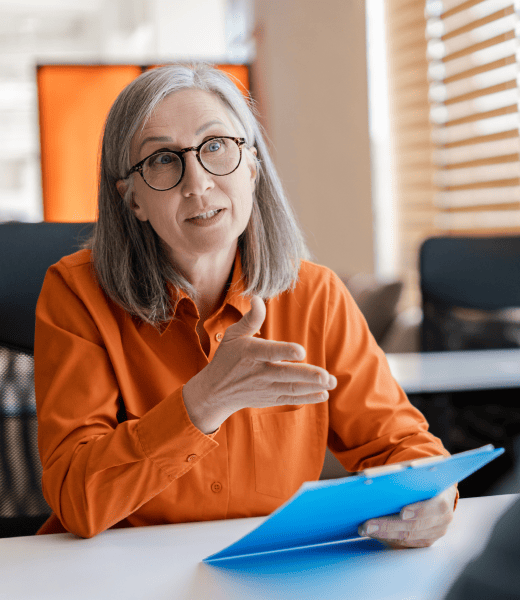 Woman in an office explaining a concept with the help of a clip board.