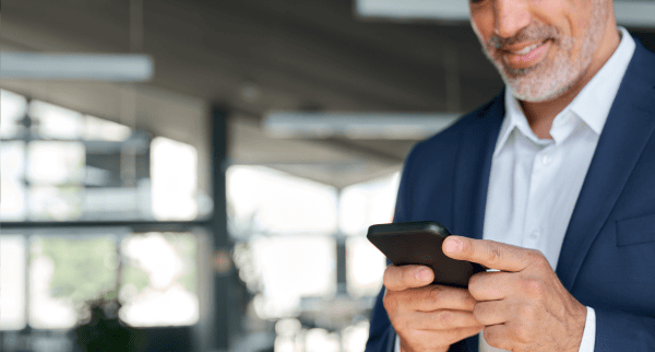 A man in a suit looking at his phone.