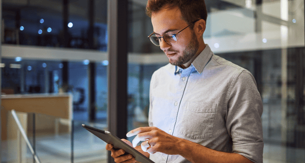 A man in an office looking at his tablet.