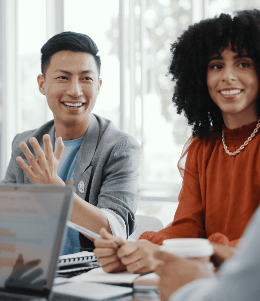 Two people in a business meeting with laptops and notebooks